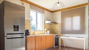 A compact kitchen with a refrigerator, stove, and sink. - 4-bedroom villa in lovely Mili with AC, WiFi. Enjoy a relaxing stay (MILI)