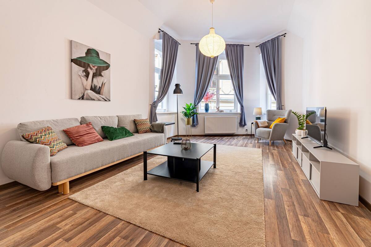 A modern living room with a sofa, coffee table, and a TV stand.