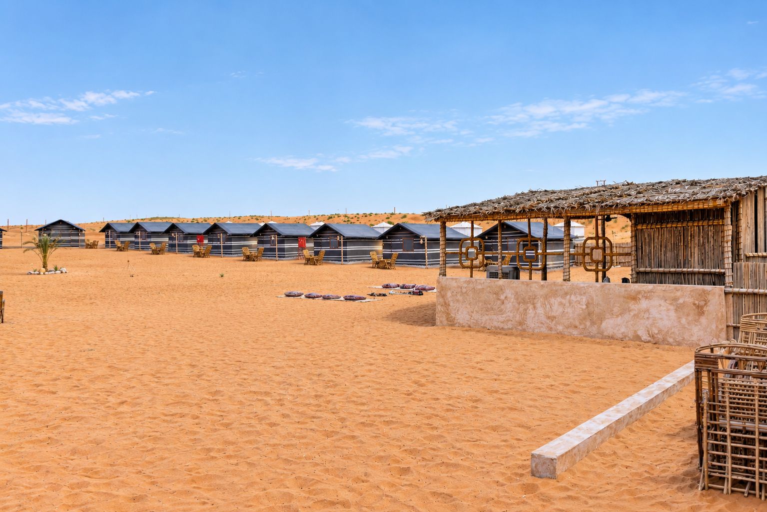 A desert landscape with multiple beach huts and a thatched-roof structure.
