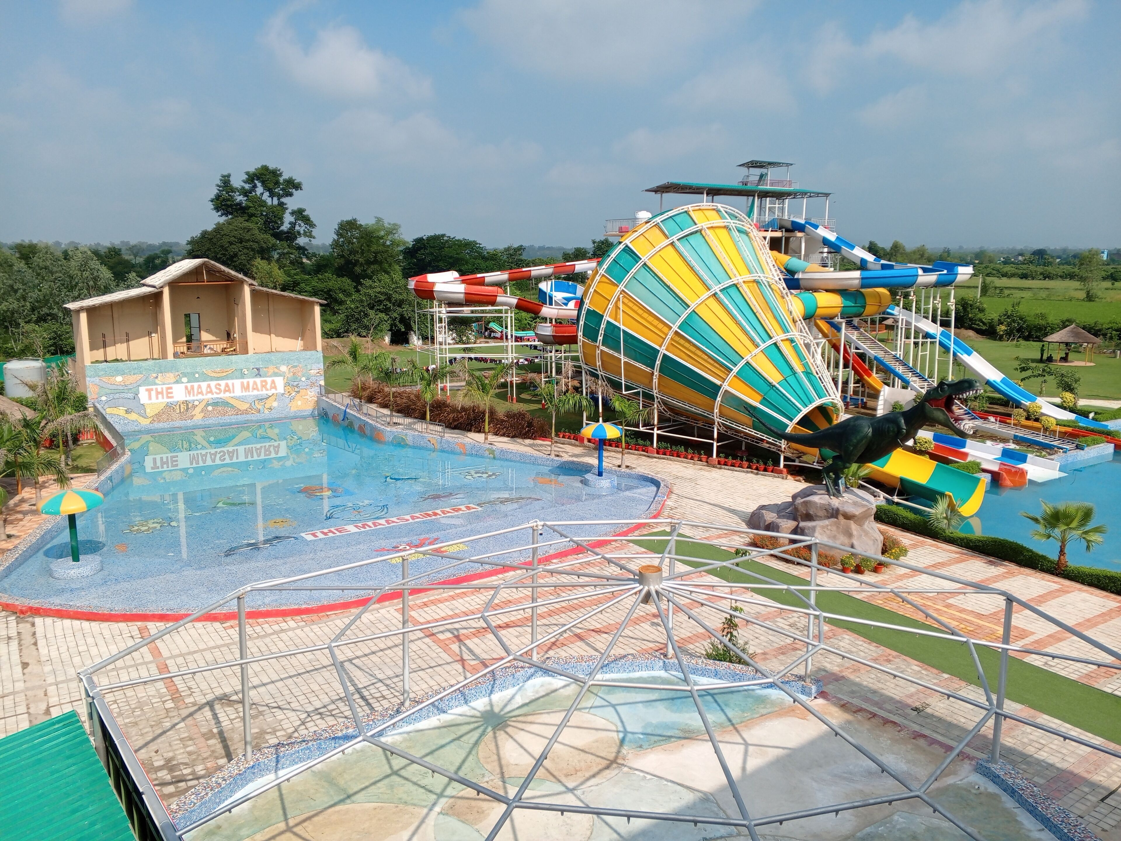 Un parc aquatique doté d’un grand toboggan, d’une piscine et d’un bâtiment portant l’inscription « The Maasai Mara ».