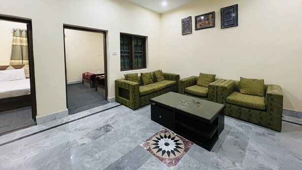 A living room with a sofa set, a coffee table, and a patterned rug.