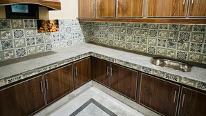 A kitchen with wooden cabinets, a tiled backsplash, and a built-in oven.