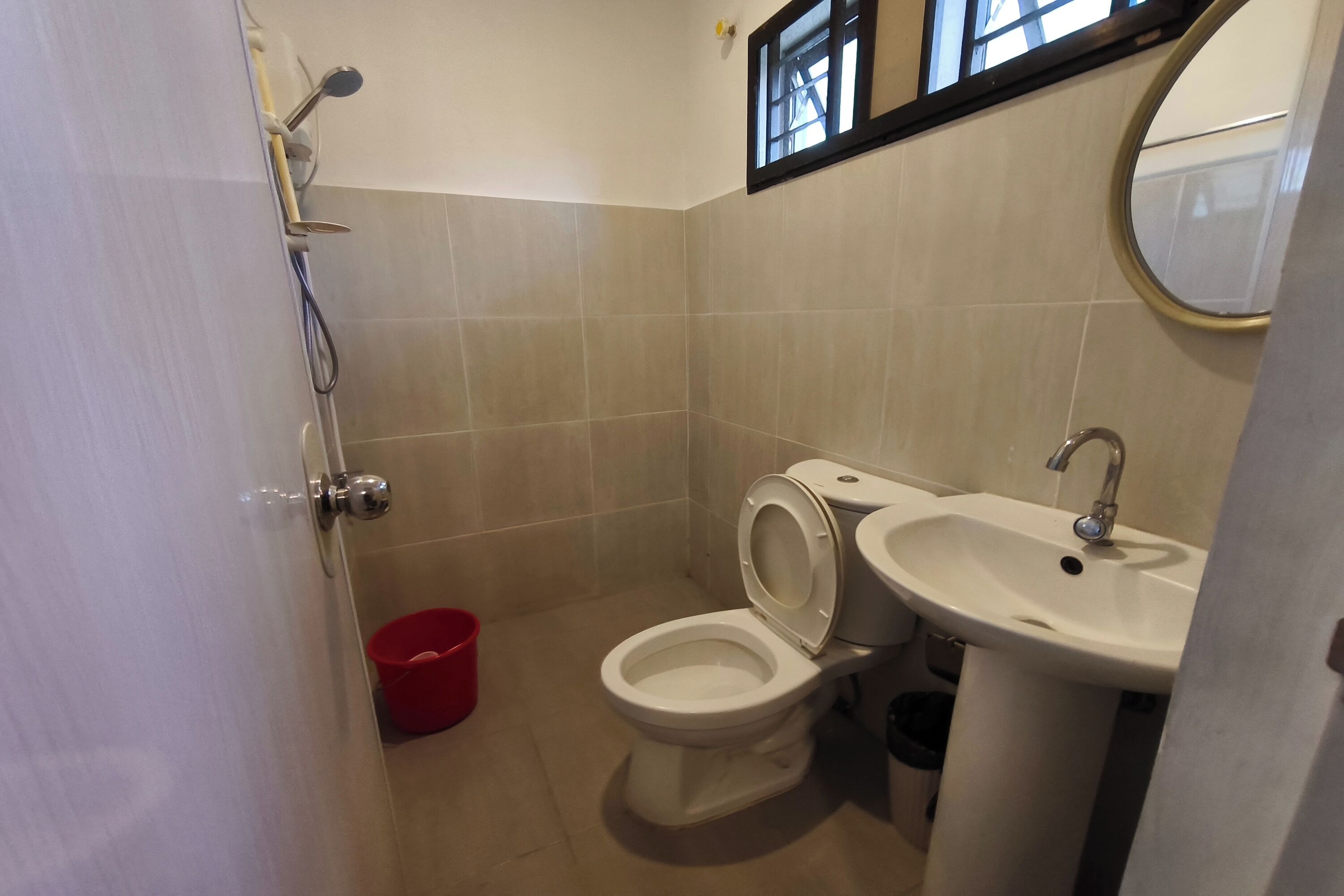 Un baño pequeño con inodoro, lavabo y ducha.