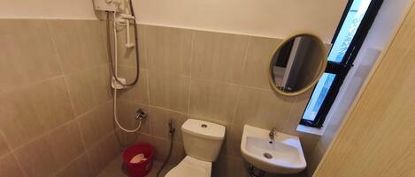 Un baño pequeño con inodoro, lavabo y ducha.