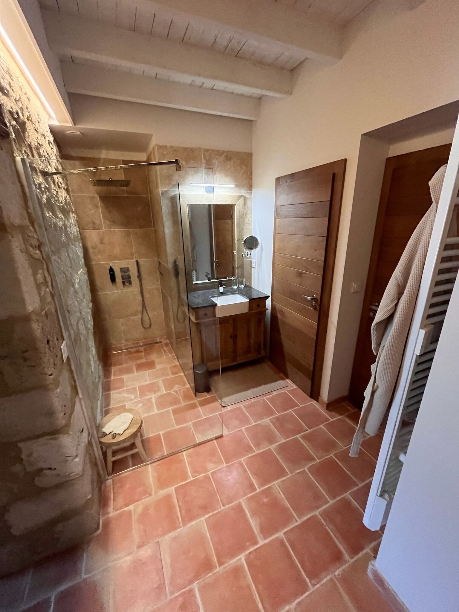 A bathroom with a shower, a sink, and a mirror.