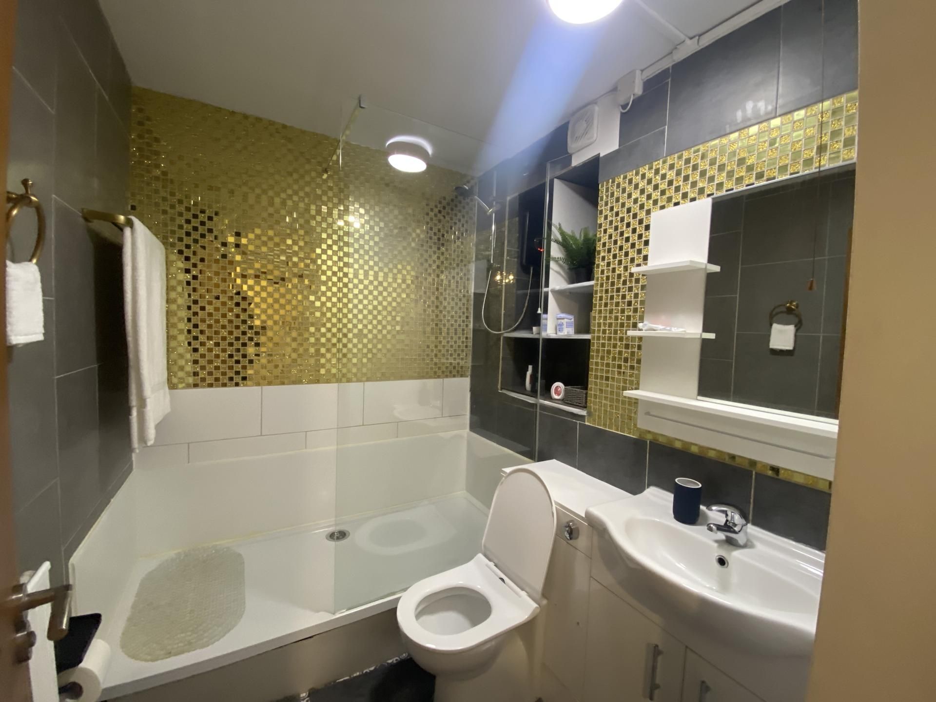 Un baño moderno con bañera, inodoro y lavamanos.