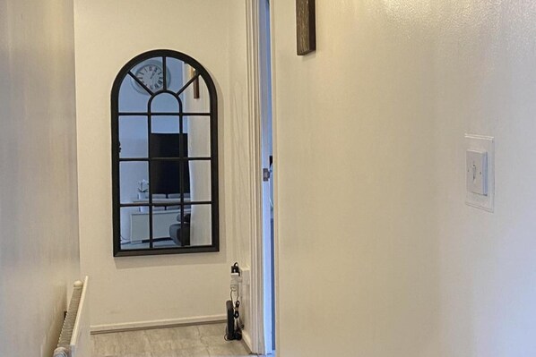A hallway with a large arched window, a radiator, and a power outlet on the wall. - Apartment - Sleeps 2 & Free Parking (Birmingham)