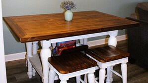 A dining table with chairs, a hanging light fixture, and framed pictures on the wall. - Third floor view overlooking canal (Rockport)