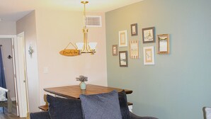 A living room with a sofa, a wooden coffee table, and a dining table with chairs. - Third floor view overlooking canal (Rockport)