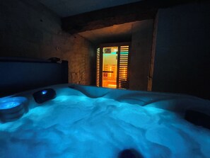 Una habitación con una superficie amplia y climatizada que recuerda a la nieve, una pequeña mesa con una lámpara y una puerta que da a una zona muy iluminada.