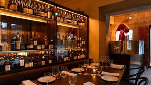 A bar area with shelves of wine bottles, glasses, and neatly set dining tables. - 2BR with Parking | Walk to QPAC & South Bank (South Brisbane)