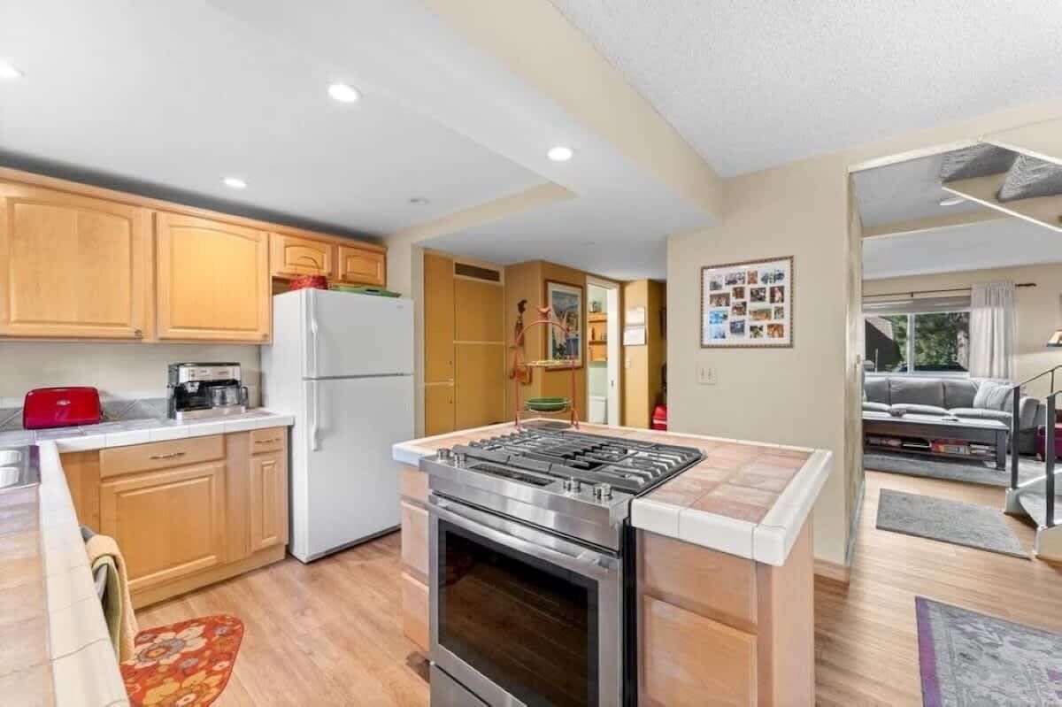 Una cucina moderna con mobili in legno, forno integrato e piano cottura a gas.