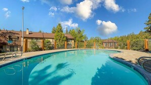 A swimming pool with a clear blue water surface, surrounded by a fence and trees. - Two Story Townhome with Hot Tub, Walk to Lake (Tahoe City)