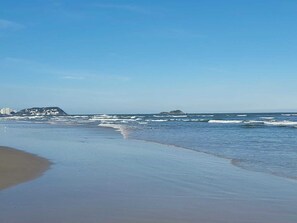 Playa en los alrededores, playa de arena blanca y sombrillas 