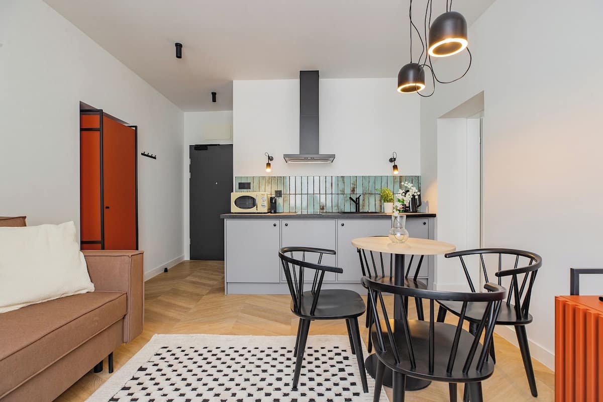 A modern kitchen with a central island, two pendant lights, and a built-in microwave.