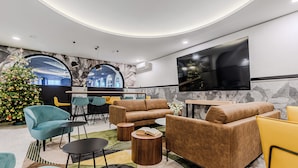 Un espace de détente moderne avec des canapés, des fauteuils et un sapin de Noël.
