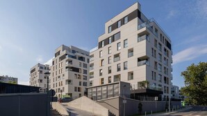 A modern apartment complex with multiple buildings, a central staircase, and a clear sky. - Bright Apartment with a Balcony | Lake View, Bicycles (Katowice)