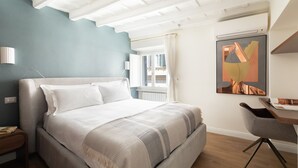 Une chambre moderne avec un grand lit, un bureau et une fenêtre avec des rideaux.