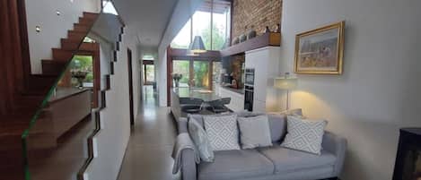 Een modern interieur met een trap, een bank en een keukenhoek.