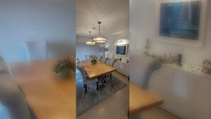 Ein stilvoller Essbereich mit Holztisch, grau gepolsterten Stühlen, Pendelleuchten und einem grauen Teppich.