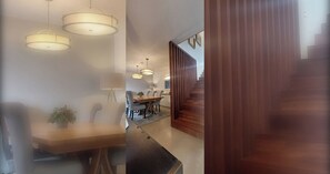 A modern interior with a dining area, kitchen, and staircase.
