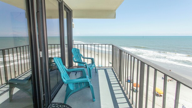 Ein Balkon mit Blick auf Strand und Meer.