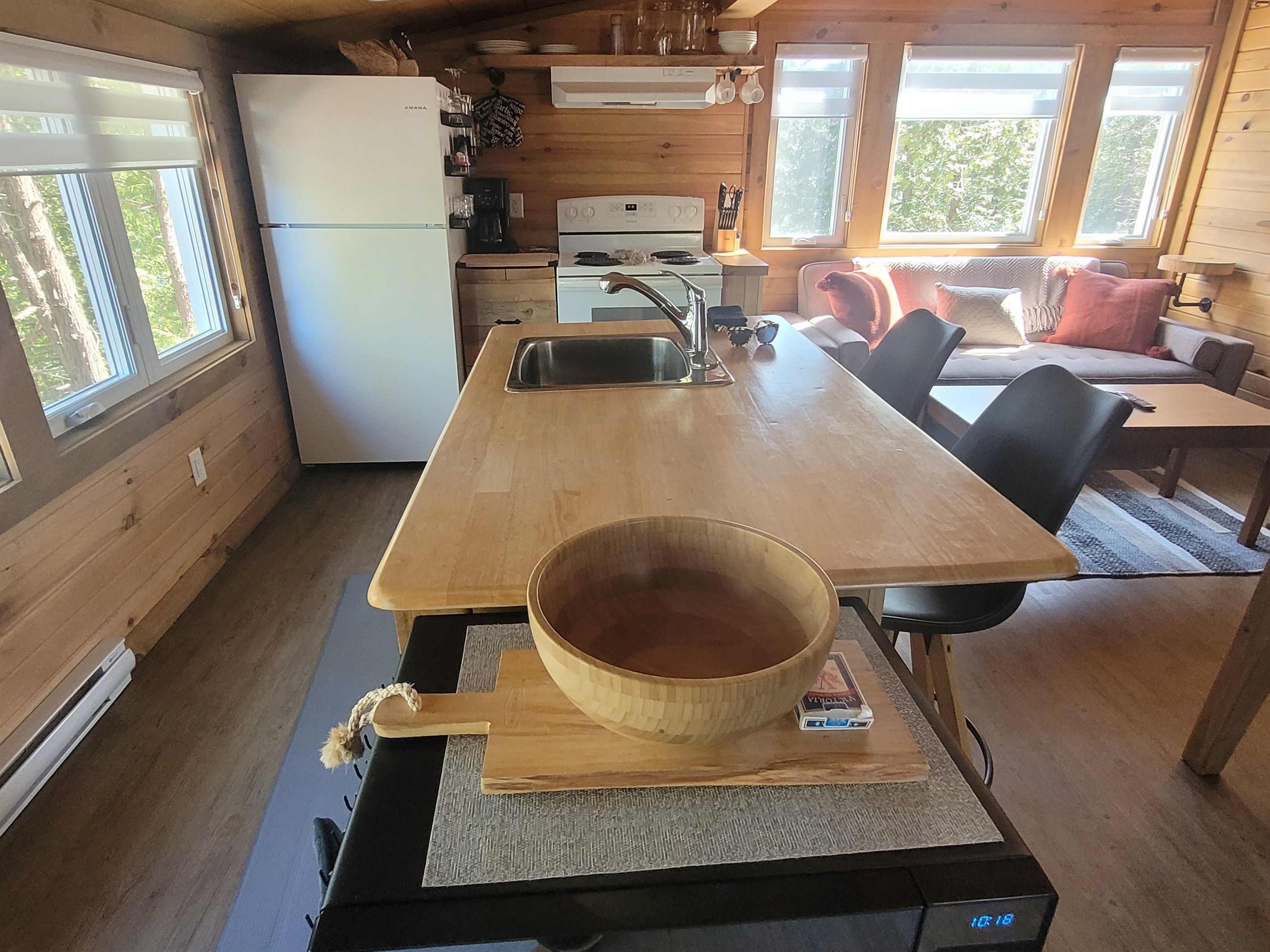 A compact kitchen with a wooden table, a sink, and a refrigerator.