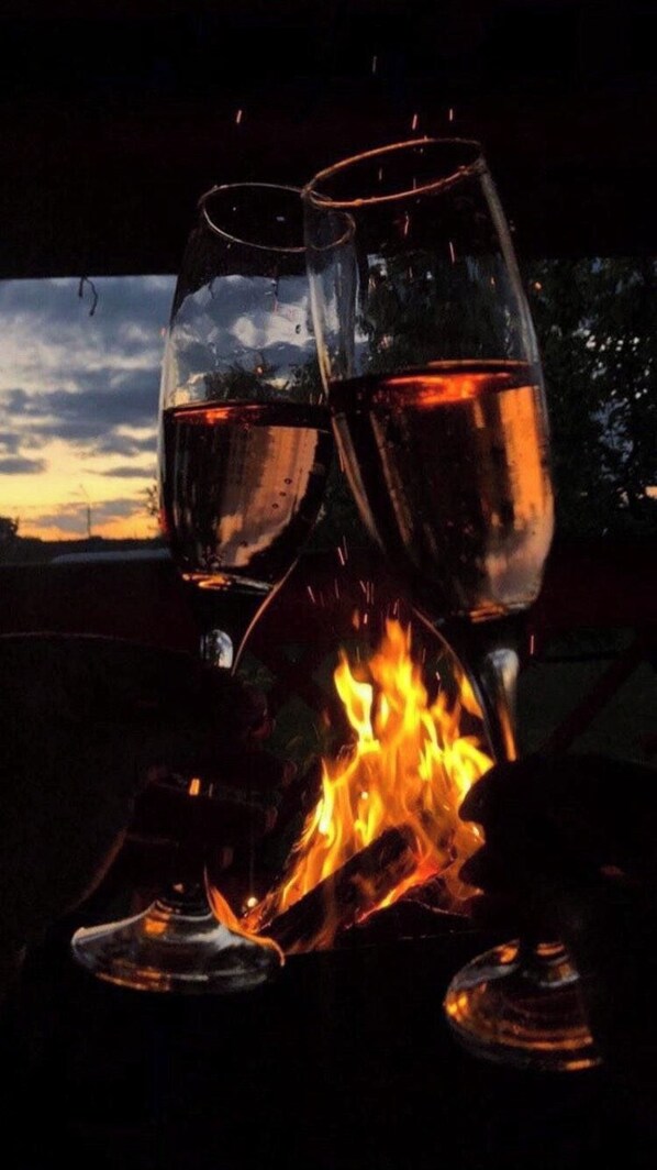 Dos copas de vino llenas de un líquido oscuro, sobre un fuego.