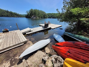A wooden dock extending into a calm lake, surrounded by dense forest. - Intimate Cottage plus Loft with Epic Lake Views (Val-des-Monts)