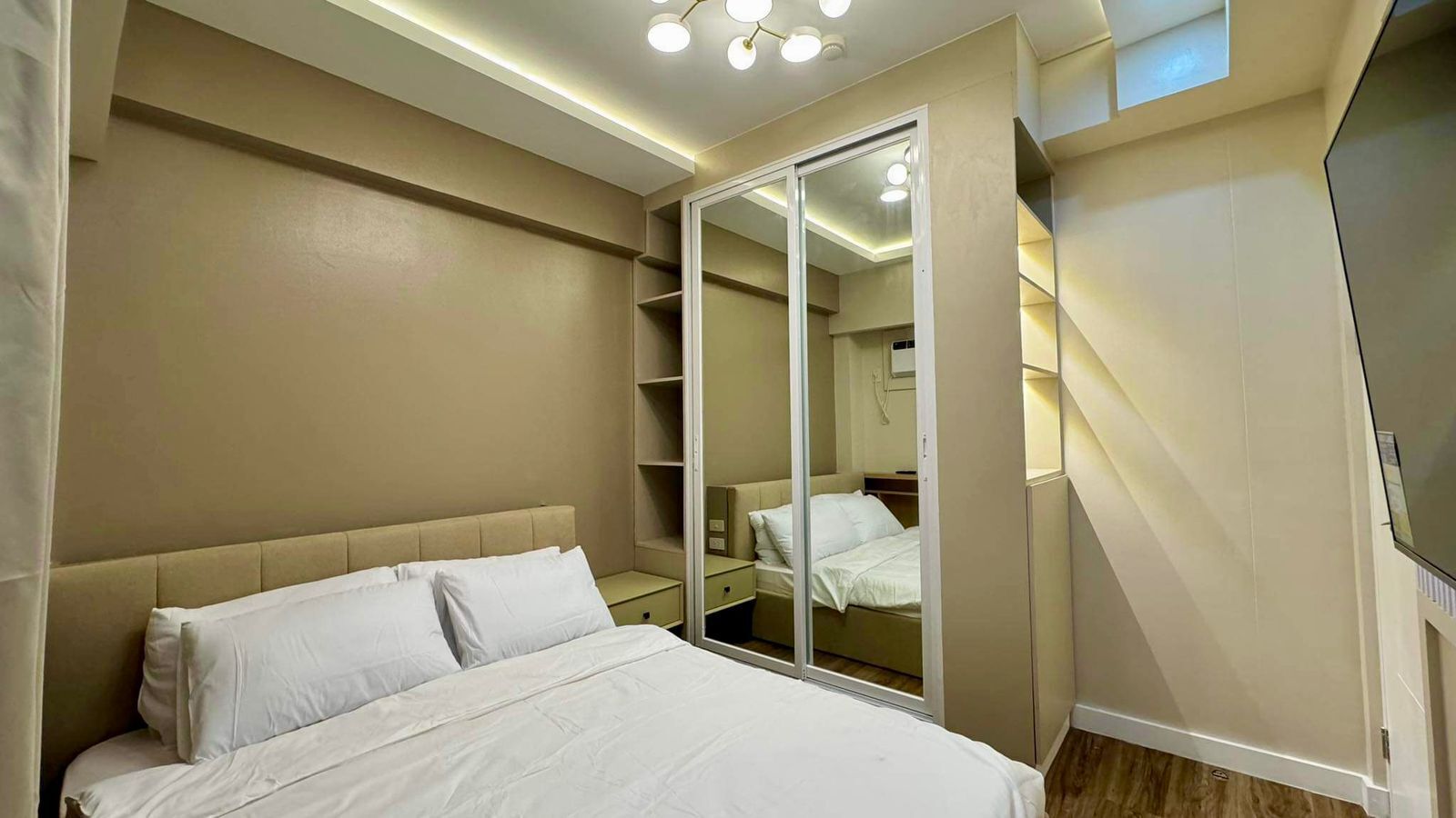 A bedroom with a bed, a wardrobe, and a mirror.
