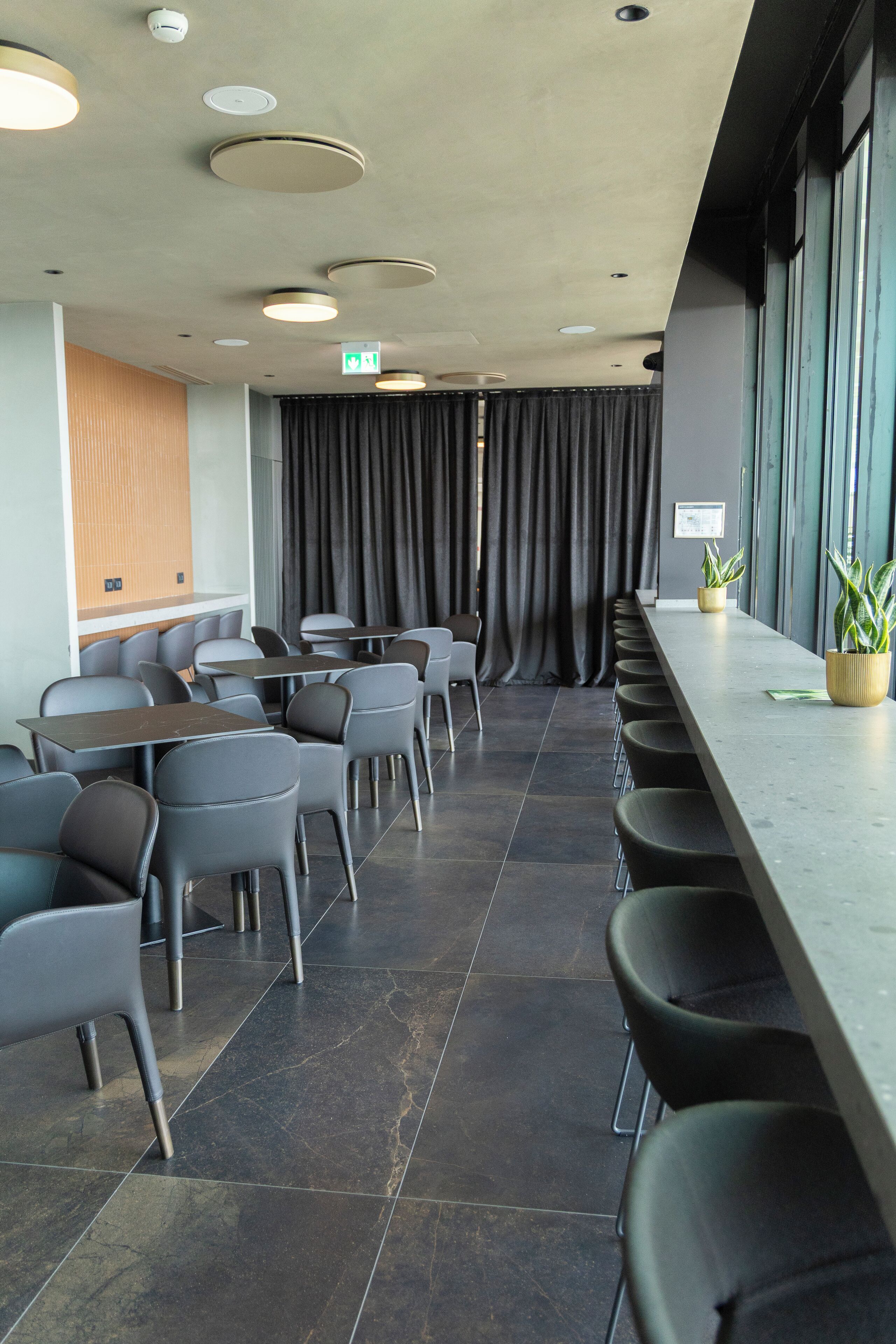 A conference room with a long table, chairs, and potted plants.