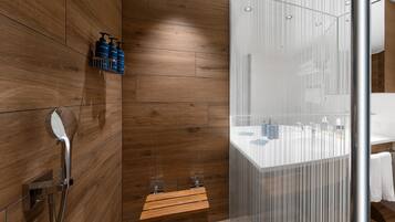 A modern bathroom with wooden paneling, a glass shower enclosure, and a white vanity with a towel rack.