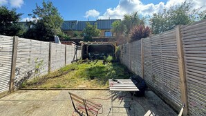 A backyard with a pergola, a table with tools, and a wooden fence. - Delightful 3BD Terrace House, Near London Bridge (Greater London)