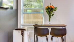Ein Zimmer mit Fenster, Schreibtisch, zwei Stühlen und einer Heizung.