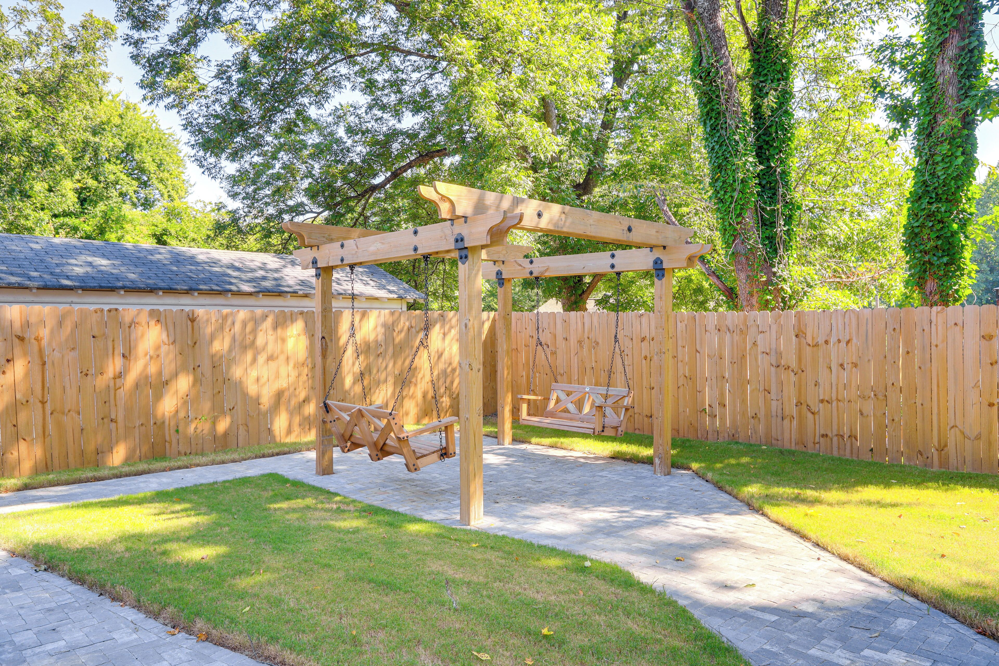 Eine hölzerne Pergola mit Schaukeln im Garten.