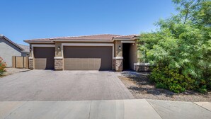 Ein Wohnhaus mit Garage, befestigter Auffahrt und angelegtem Garten.