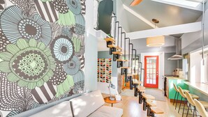 A modern interior with a staircase, seating area, and a kitchen. - 3 Mi to Boothbay Harbor: Coastal Colorful Home! (East Boothbay)