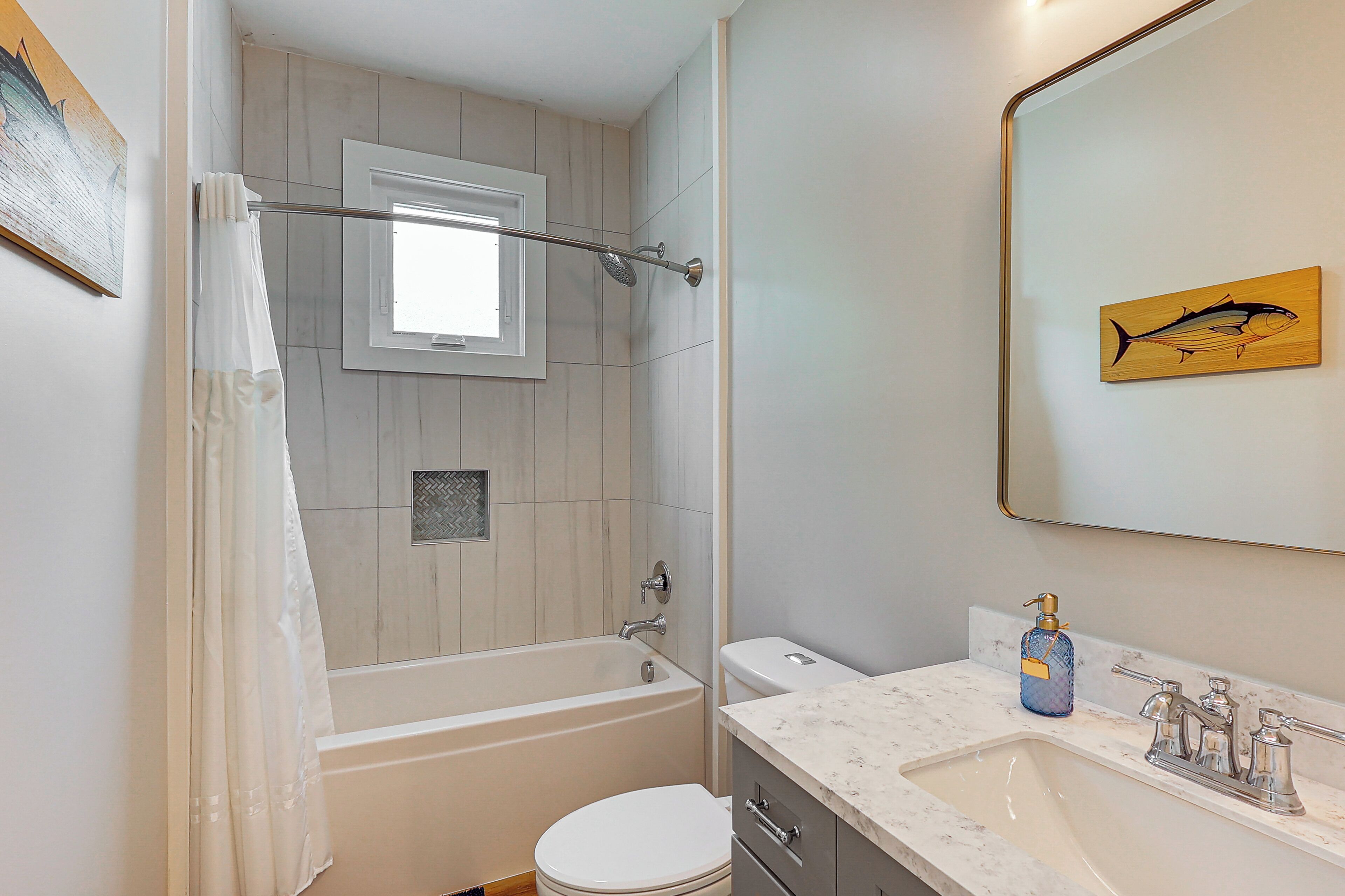 A modern bathroom with a bathtub, toilet, and sink.