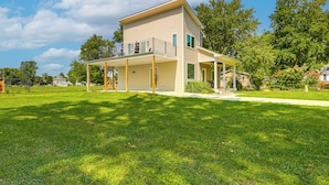 A two-story house with a balcony, a covered porch, and a well-maintained lawn. - Rock Hall Retreat w/ Balcony Near Park & Marina! (Rock Hall)