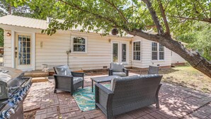 A patio with wicker furniture, a grill, and a house in the background. - Pet Friendly Home w/ Yard & Grill in Crowell! (Crowell)