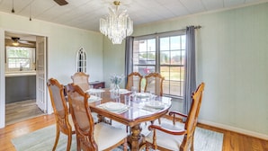 A dining room with a wooden table set for six, surrounded by six wooden chairs with cushioned seats. - Pet Friendly Home w/ Yard & Grill in Crowell! (Crowell)