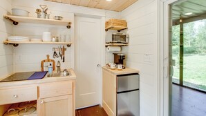 A compact kitchen with wooden shelves, a built-in oven, and a refrigerator. - Ice Fishing on South Fork Lake: Nashwauk Studio! (Nashwauk)