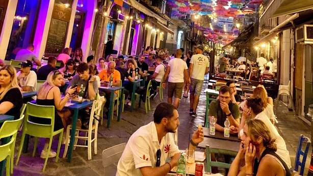 An outdoor dining area with colorful umbrellas overhead and people seated at tables. - San Martino House at the Cathedral (Catania)