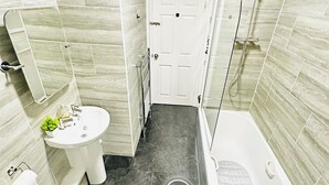 A bathroom with a white sink, a toilet, and a bathtub. - 5bed-10 Guests-near City Centre-free Parking (Leeds)