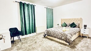 A bedroom with a bed, a chair, a nightstand, and a radiator. - 5bed-10 Guests-near City Centre-free Parking (Leeds)
