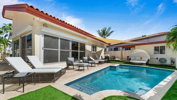 A residential property with a swimming pool, outdoor seating, and a covered patio area. - Aruba Oasis! 3BR Home w Pool & BBQ near Palm Beach (Noord)