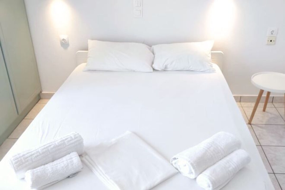 A hotel room with a bed, pillows, and towels.