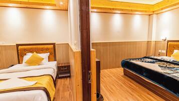 Habitación de hotel con dos camas, suelo de madera y techo de madera.