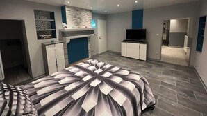 A modern bedroom with a large bed, built-in wardrobe, and a television. - Small house in the country, with terrace!  Pets allowed. (Osne-le-Val)