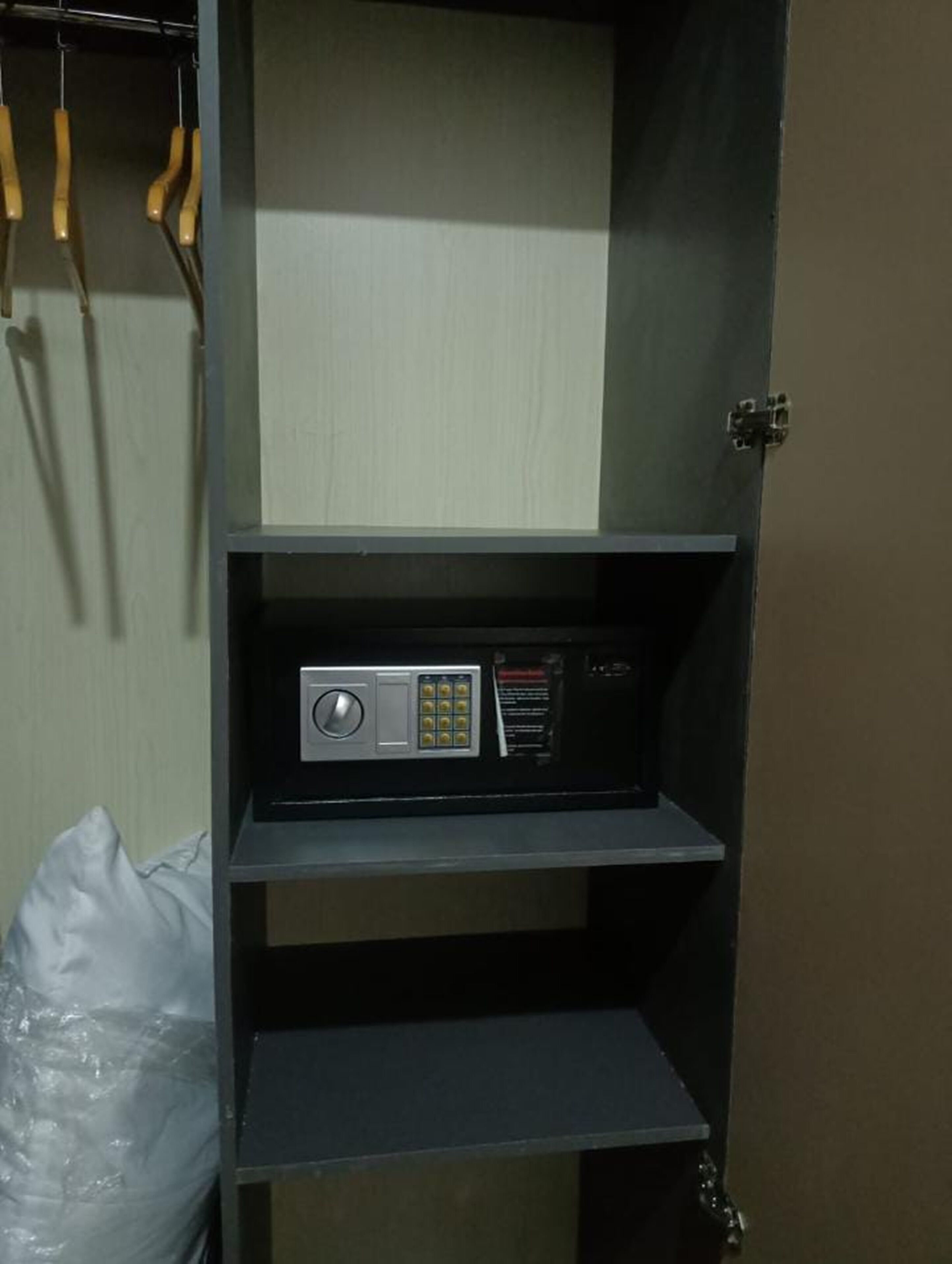 A storage unit with shelves, a radio, and a plastic bag.